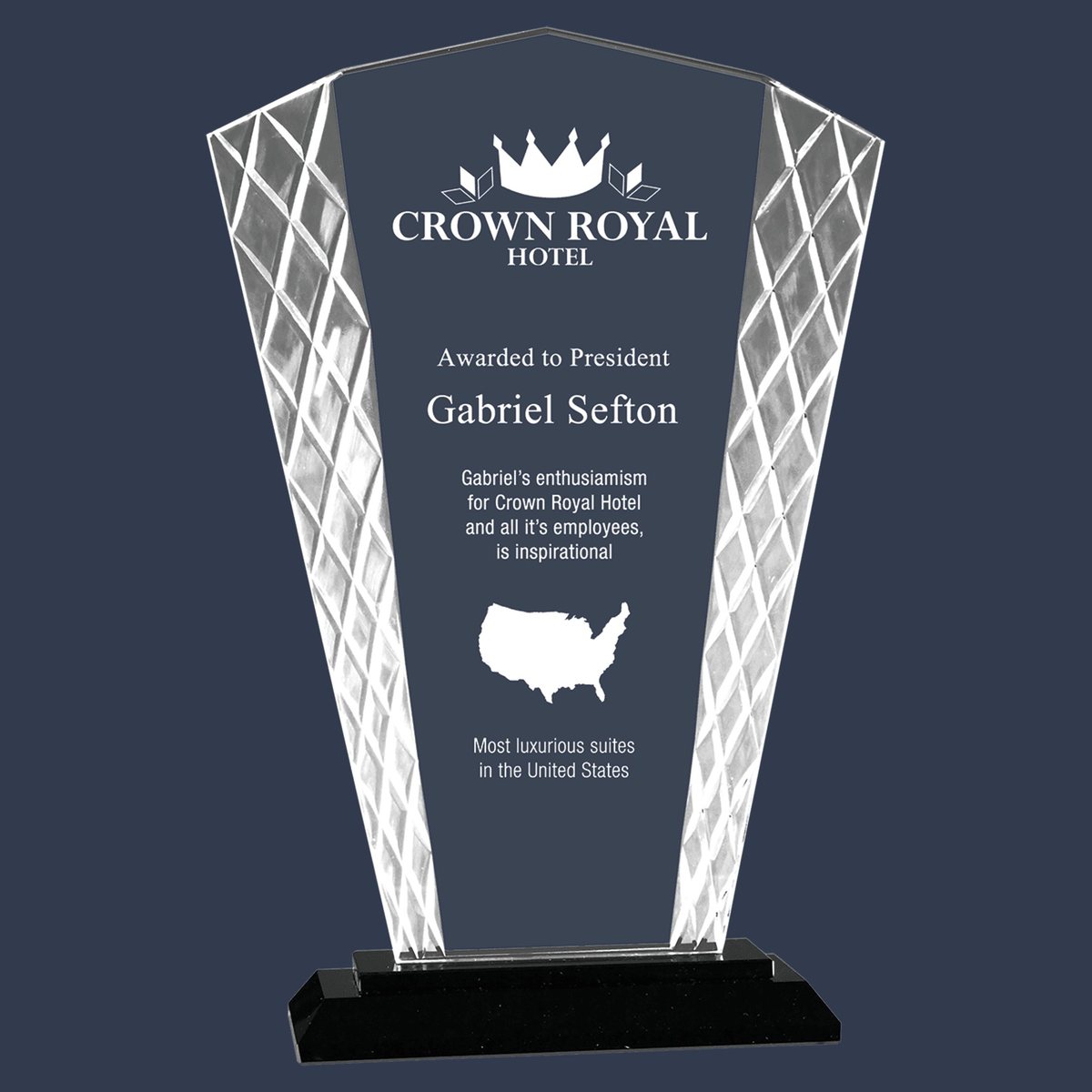 A faceted crystal award engraved with a hotel crown logo, a dedication and a map of the United States.