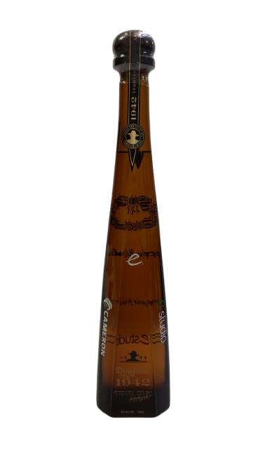 A tall tequila bottle etched down its length with a company mark and name.