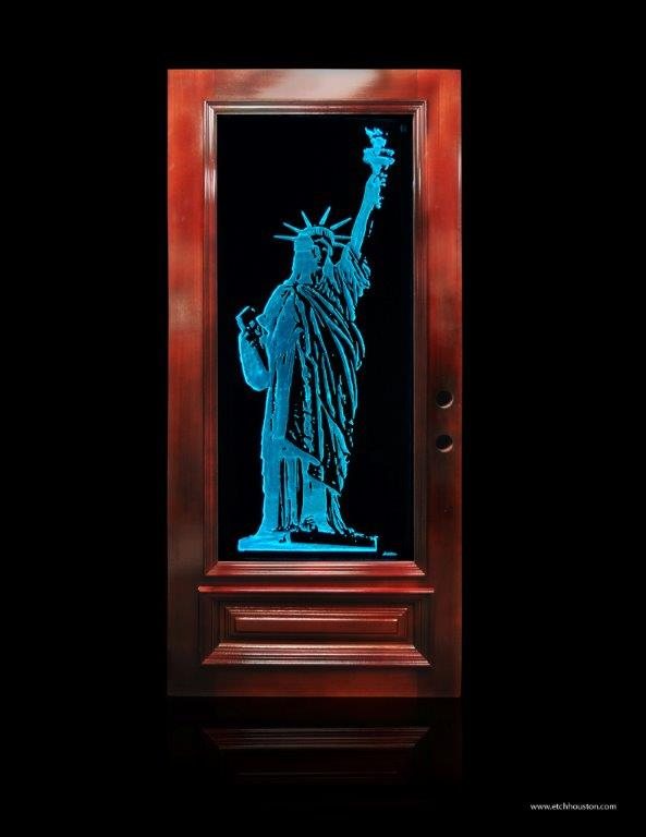 A door glass panel carved with the Statue of Liberty, lit turquoise from within.