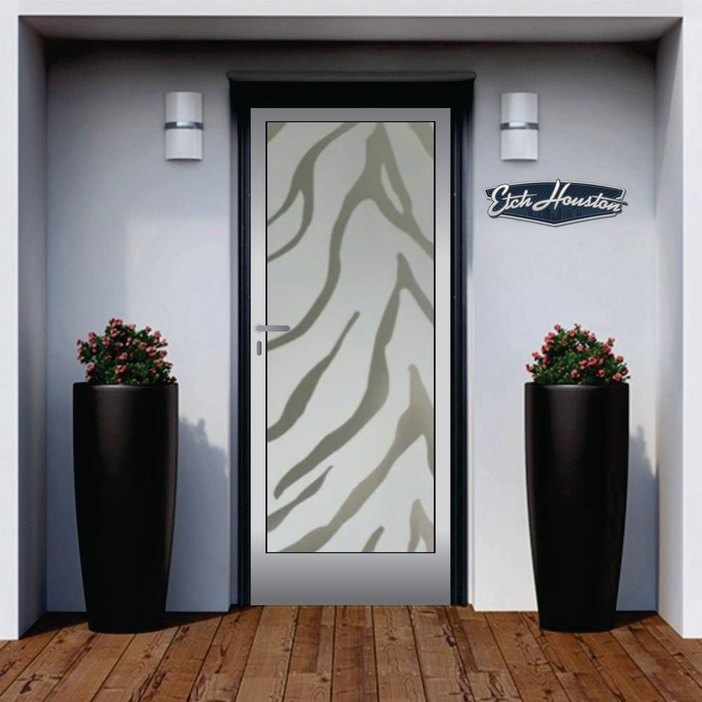 An entrance door with a decorative glass panel carrying a zebra-stripe pattern, between two tall black planters.