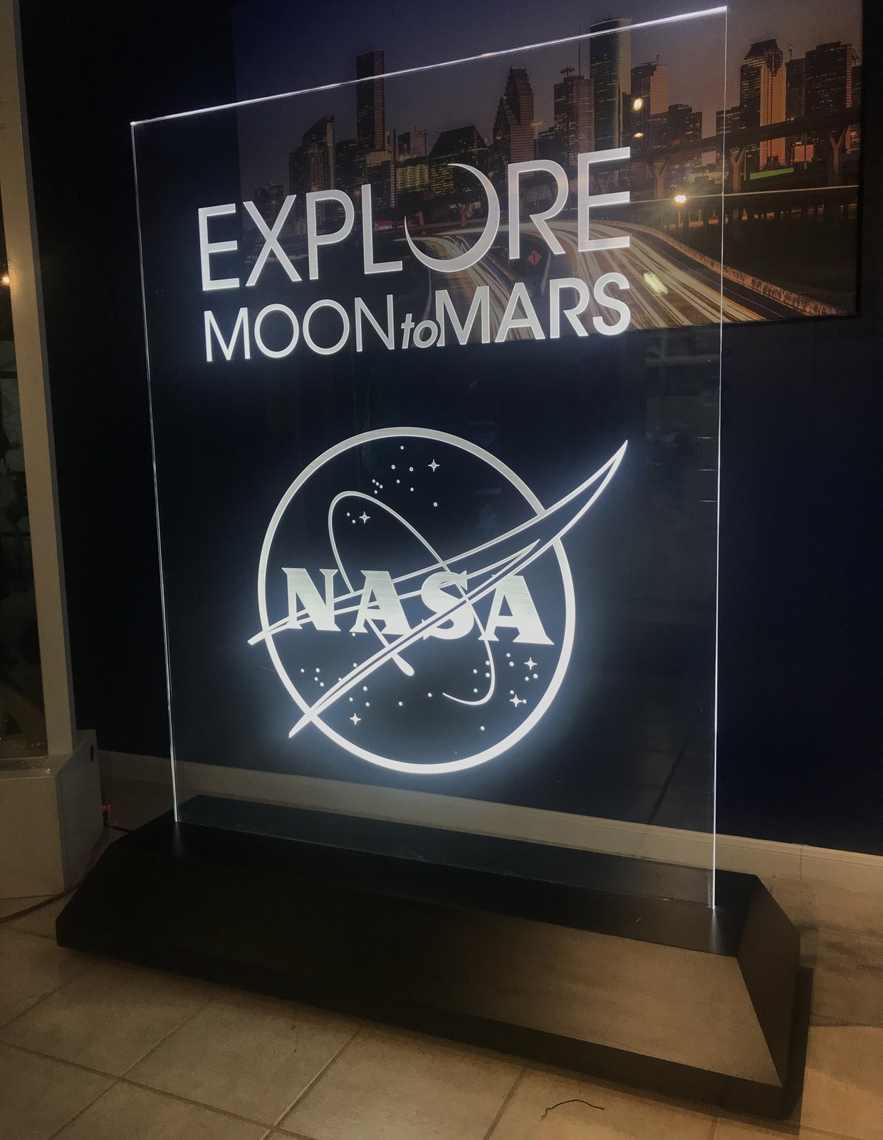 An illuminated etched glass display panel lit from the base, showing a space-programme graphic.