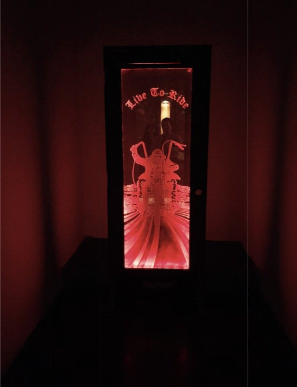 A tall carved glass insert lit deep red, set into a dark panelled door surround.