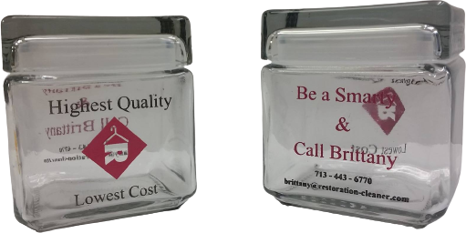 A pair of square glass canisters with chrome lids, each printed with a cleaning company's branding, slogan and contact details.