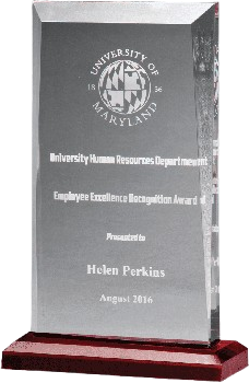 A crystal recognition award on a red base, etched with a University of Maryland seal and an Employee Excellence Recognition Award presented to Helen Perkins, August 2016.