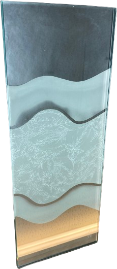 A tall carved glass panel with a layered wave landscape sand-carved across it, standing on a lit base.