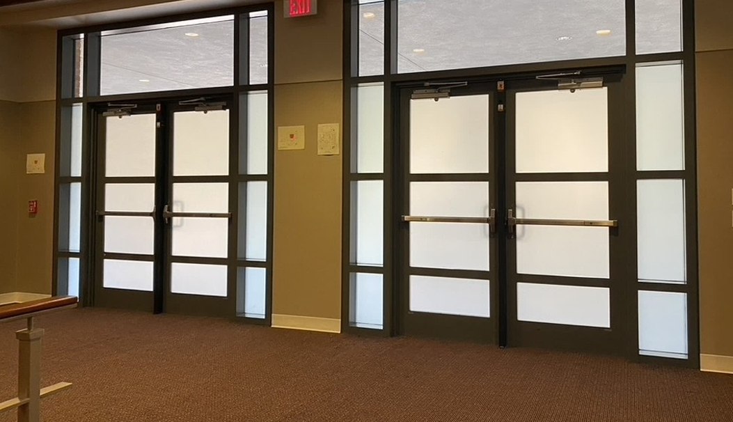 Full-height switchable glass doors in an office, frosted for privacy.