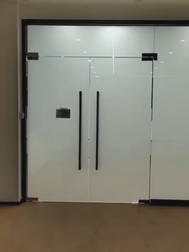 A glass office partition with double doors, powered off: the whole wall is frosted white.