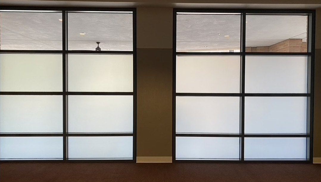 A run of gridded Smart Glass panels forming an office wall, photographed in the frosted state.
