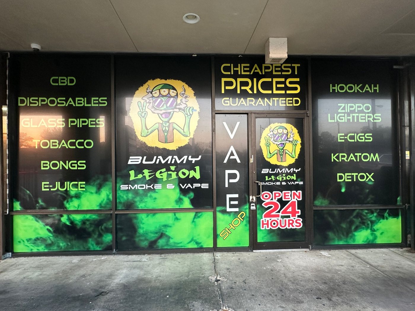 A shop window run printed edge to edge in black and green, listing the products down both sides of the entrance.