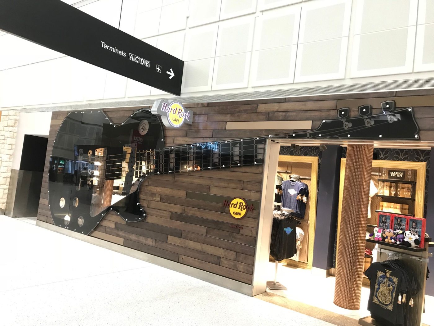 The same guitar shopfront seen along the concourse, with the Hard Rock Cafe sign above the entrance.